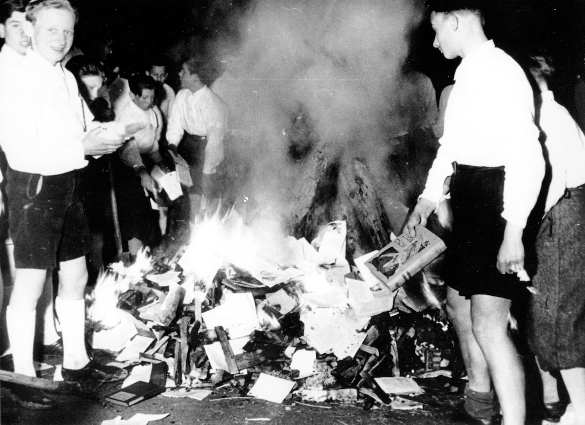 A photograph of a group of young Nazis burning a pile of books.